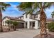 Two-story house with tile roof, three-car garage, and palm trees at 19668 E Carriage Way, Queen Creek, AZ 85142
