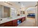 Spa-like bathroom with double vanity and view into the main bedroom at 5677 S 239Th Dr, Buckeye, AZ 85326