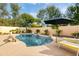 Inviting kidney-shaped pool with lounge chairs and patio umbrella at 6113 E Gelding Dr, Scottsdale, AZ 85254