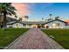 Stunning mid-century modern home with brick pathway, lush landscaping, and mountain views at 6302 E Hillcrest Blvd, Scottsdale, AZ 85251