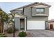 Two-story house with gray siding, white garage door, and landscaped front yard at 11311 E Upton Ave, Mesa, AZ 85212
