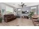 Living room with brown sofas, large TV, and ceiling fan at 11311 E Upton Ave, Mesa, AZ 85212