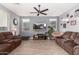 Spacious living room featuring brown sofas and a large TV at 11311 E Upton Ave, Mesa, AZ 85212