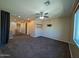 Living room with carpet, ceiling fan, and access to other rooms at 12029 W Overlin Ln, Avondale, AZ 85323