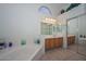 Elegant bathroom with a bathtub, double vanity, and linen closet at 14423 W Morning Star Trl, Surprise, AZ 85374