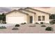 Tan single-story house with two-car garage and desert landscaping at 1727 W Posada St, Coolidge, AZ 85128