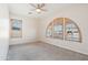 Bright bedroom with carpet flooring, ceiling fan, and large windows with plantation shutters at 18133 W Las Cruces Dr, Goodyear, AZ 85338