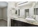 Elegant bathroom with double sinks, granite countertops, and dark brown cabinets at 18407 W Fulton St, Goodyear, AZ 85338