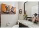 Stylish bathroom with granite countertop, decorative mirror, and western-themed art at 18407 W Fulton St, Goodyear, AZ 85338
