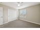 Spacious bedroom with plush carpeting, white closet doors, and a window with plantation shutters at 18407 W Fulton St, Goodyear, AZ 85338