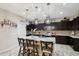 Kitchen with granite island, dark cabinets, and stainless steel appliances at 18407 W Fulton St, Goodyear, AZ 85338