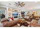 Open living area with leather couches, a rustic coffee table, and a large TV at 18407 W Fulton St, Goodyear, AZ 85338