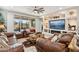 Spacious living room with leather sofas, built-in shelving, and a large TV at 18407 W Fulton St, Goodyear, AZ 85338