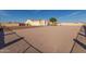 Property front view with gravel yard and gated entry at 34720 W Durango St, Tonopah, AZ 85354