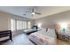 Primary bedroom with a king bed, and a twin bed, bay window, and ceiling fan at 15420 N 160Th Ln, Surprise, AZ 85374
