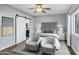 Main bedroom with barn door, ceiling fan, and two armchairs at 1610 N Stapley Dr # 104, Mesa, AZ 85203