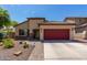 Single-story home with red garage door and landscaped yard at 17929 W Alice Ave, Waddell, AZ 85355