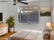 Bedroom with large window, wooden floors and ceiling fan at 1952 S Mara Dr, Apache Junction, AZ 85120