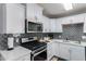 White kitchen with stainless steel appliances and gray backsplash at 7039 E Virginia Ave, Scottsdale, AZ 85257