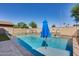 Relaxing pool area with a blue umbrella and safety fence at 7244 E Olla Ave, Mesa, AZ 85212