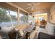 Relaxing screened porch with wicker furniture, ceiling fan and view of backyard at 12638 W Parkwood Dr, Sun City West, AZ 85375