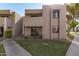 Tan two-story condo building with walkway and landscaping at 1920 W Lindner Ave # 147, Mesa, AZ 85202