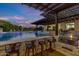 Outdoor kitchen and bar area next to a refreshing pool at 21934 E Stone Crest Ct, Queen Creek, AZ 85142