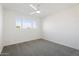 Simple bedroom with grey carpet and a large window at 2504 N Papago Dr, Tempe, AZ 85288