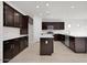 Modern kitchen with island, stainless steel appliances, and dark brown cabinetry at 2518 N Pony Ln, Casa Grande, AZ 85122