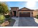 Front view of home with brown garage door and desert landscaping at 26653 W Firehawk Dr, Buckeye, AZ 85396