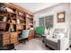Home office with built-in shelving, a desk, and a comfortable armchair at 26653 W Firehawk Dr, Buckeye, AZ 85396