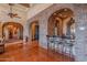 Elegant bar with brick accents and wrought iron stools at 5681 E Canyon Ridge North Dr, Cave Creek, AZ 85331
