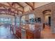 Open kitchen with large island, exposed beams, and stone accents at 5681 E Canyon Ridge North Dr, Cave Creek, AZ 85331
