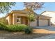 Single-story house with a two-car garage and lush green landscaping at 8411 W Myrtle Ave, Glendale, AZ 85305