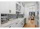 Butler's pantry with white cabinets, quartz countertops, and a farmhouse sink at 11438 N 70Th St, Scottsdale, AZ 85254