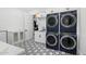 Laundry room with navy blue washer and dryer and geometric tile floor at 11438 N 70Th St, Scottsdale, AZ 85254