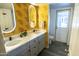 Modern bathroom with a double vanity and yellow leaf wallpaper at 1440 E Secretariat Dr, Tempe, AZ 85284