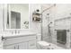 Modern bathroom with white vanity, glass shower, and patterned tile at 18373 W Sells Dr, Goodyear, AZ 85395