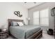 Bright bedroom with wood-framed bed, window shutters, and wall decor at 18373 W Sells Dr, Goodyear, AZ 85395