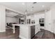 Open concept kitchen with island, stainless steel appliances, and views into the living room at 18373 W Sells Dr, Goodyear, AZ 85395
