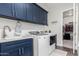 Laundry room with navy cabinets, washer, dryer and closet at 18373 W Sells Dr, Goodyear, AZ 85395