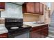 Simple kitchen with dark wood cabinets and electric range at 23523 N 79Th Ave, Peoria, AZ 85383