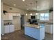 Modern kitchen with white cabinets, granite counters, and an island at 25627 W Hedgehog Rd, Wittmann, AZ 85361