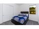 Bedroom with navy bedding, dark wood frame bed, and white closet doors at 562 N Sun Rd, Apache Junction, AZ 85119