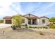 Tan house with brown roof, desert landscaping, and a paved driveway at 562 N Sun Rd, Apache Junction, AZ 85119