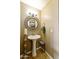 Stylish bathroom with pedestal sink, oval mirror, and tiled floor at 8689 E Windrose Dr, Scottsdale, AZ 85260