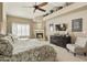Main bedroom with king-size bed, fireplace, and built-in shelving at 8689 E Windrose Dr, Scottsdale, AZ 85260
