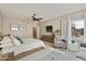 Spacious primary bedroom with a plush bed, sitting area and large window at 8689 E Windrose Dr, Scottsdale, AZ 85260