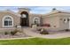 Front entry with walkway, landscaping, and a three-car garage at 8689 E Windrose Dr, Scottsdale, AZ 85260