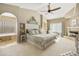 Large main bedroom with a luxurious bed, fireplace and ensuite bathroom at 8689 E Windrose Dr, Scottsdale, AZ 85260